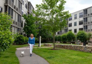 senior woman walking her dog at waterstone at wellesley