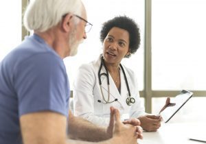 Serious retired man consulting with doctor